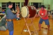 Photograph : Men are playing a Japanese traditional big drum at Bon-odori Festival.