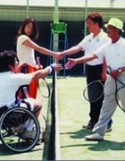 Photograph : Starting the Universal Tennis, players are two pair; one is a middle-aged man and a man of advanced age, and another is a young woman and a man in wheelchair. 